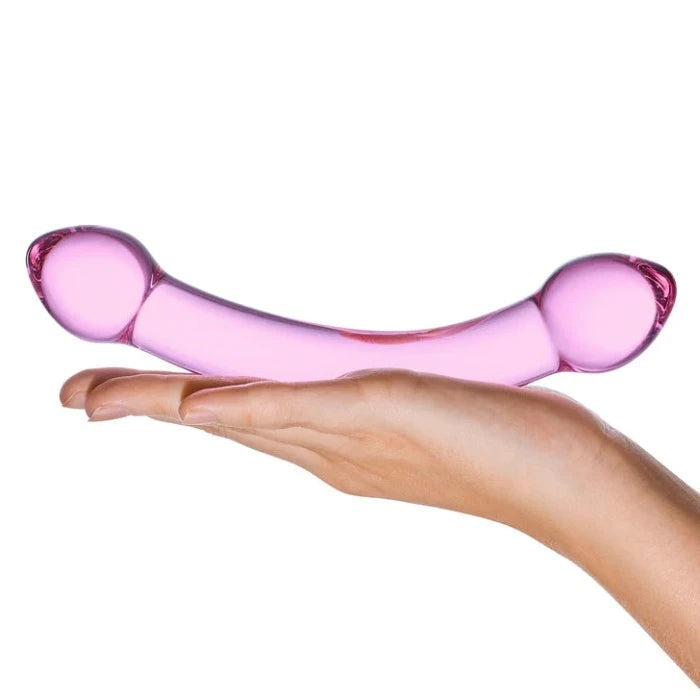 A woman holding Double Trouble Glass dildo in the palm of her hand