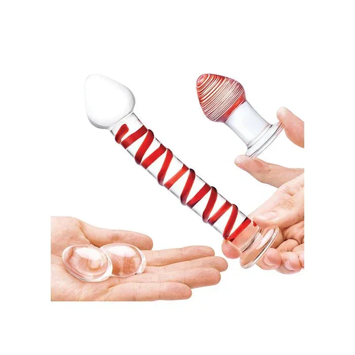 Lifestyle photo showing hand holding the curved red swirled glass dildo from the Mr. Swirly set by Glas