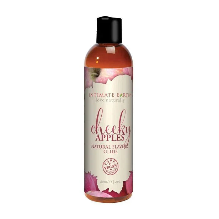 Intimate Earth Cheeky Apples Natural Flavors Glide bottle with bright green-red label featuring apple graphics; vegan, edible, pH balanced, water-based lubricant gentle on sensitive skin and safe for all erogenous zones; convenient 2 oz travel size.