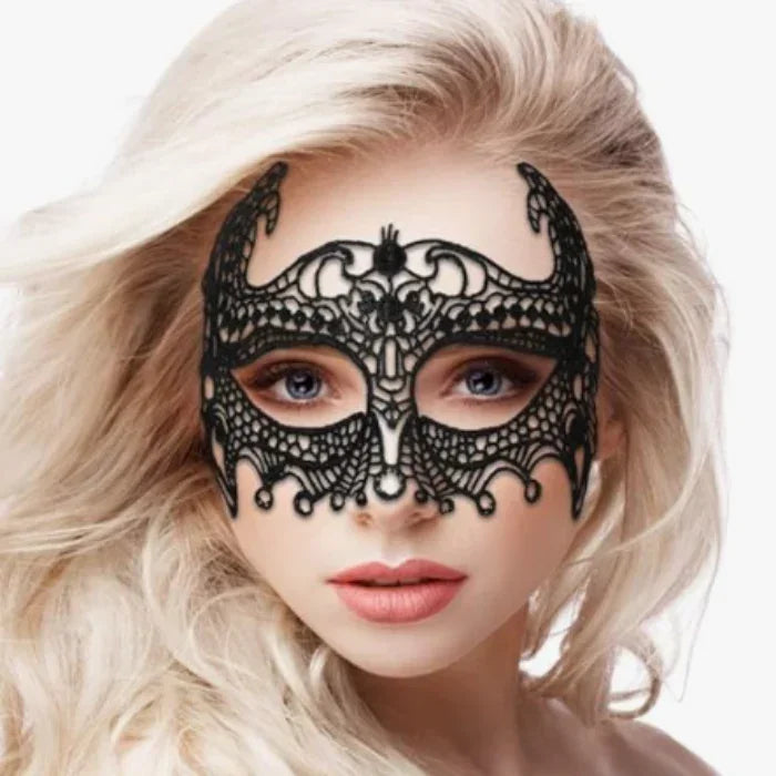 Blonde woman modeling and showing a close-up of handmade black lace Empress eye mask showing intricate detail