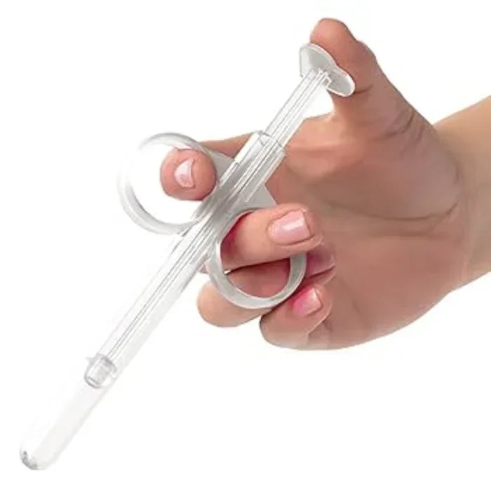 Person holding the Lube Tube demonstrating the precision lubricant applicator syringe with travel cap, made of body-safe ABS for mess-free and easy application