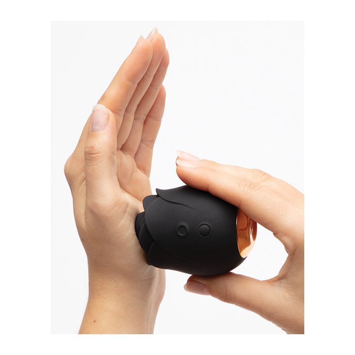 Lifestyle image showing hand holding the Hearts & Flowers Rose vibrator, emphasizing compact size