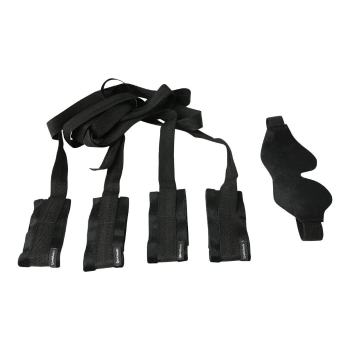 Adjustable black bondage restraints for wrists and ankles in beginner’s kit on a white background
