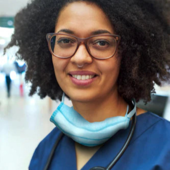 african american nurse using an essence aromatherapy nasal diffuser while working in the hospital