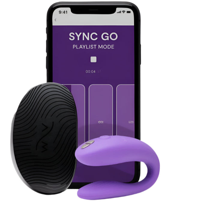 Purple We-Vibe Sync Go couples vibrator positioned beside its compact travel case, highlighting the smooth, body-safe silicone finish. An iPhone displaying the We-Vibe Sync Go app interface sits alongside the set, showcasing app-controlled features.