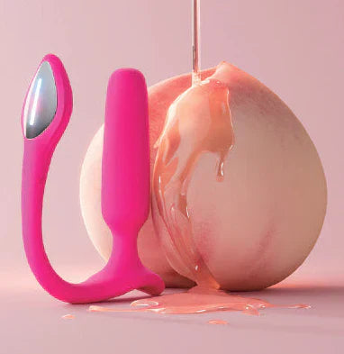 Pink Lovense Lush anal plug with lubricant dripping from peach demonstrating proper lubrication for anal play