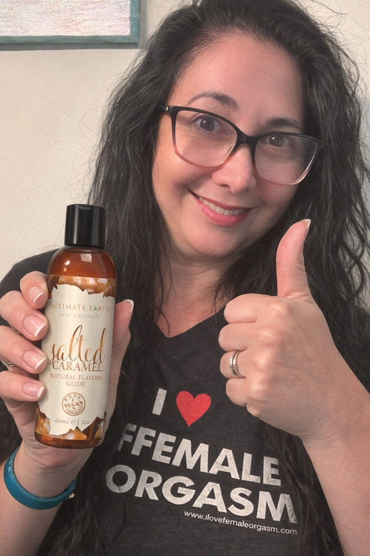 Linda Koontz, Flirtation Station Sexpert, holding Intimate Earth Salted Caramel flavored lubricant with thumbs up