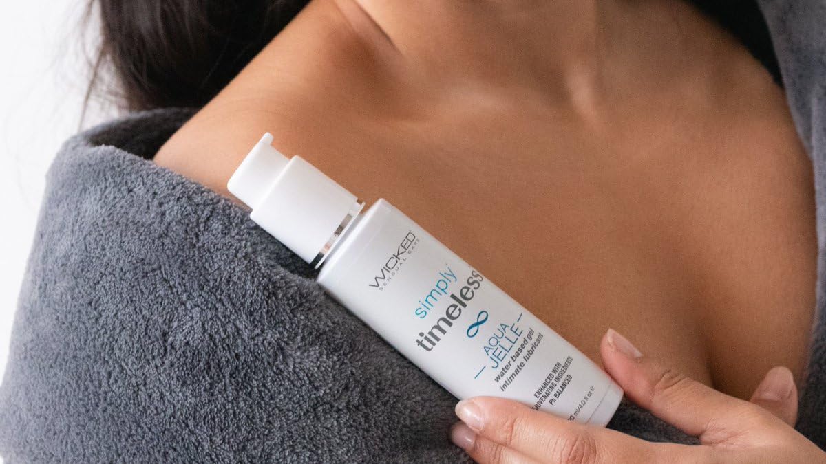 Woman holding Wicked Simply Timeless Aqua Jelle Lubricant on her shoulder