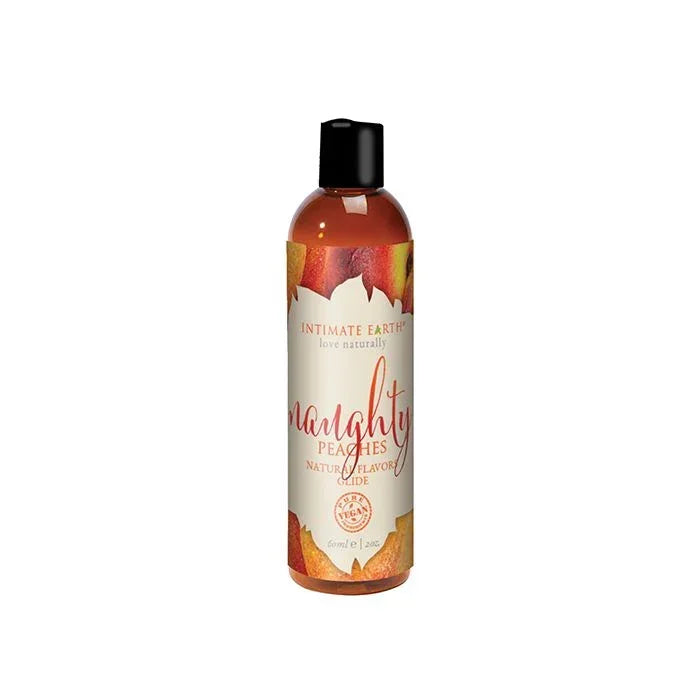 Intimate Earth Naughty Peaches Natural Flavors Glide bottle with soft peach-toned label featuring peach imagery; vegan, edible, pH balanced, water-based lubricant gentle on sensitive skin and safe for use on all erogenous zones; 2 oz travel size.