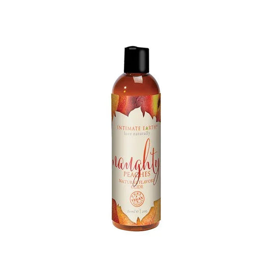 Intimate Earth Naughty Peaches Natural Flavors Glide bottle with soft peach-toned label featuring peach imagery; vegan, edible, pH balanced, water-based lubricant gentle on sensitive skin and safe for use on all erogenous zones; 2 oz travel size.