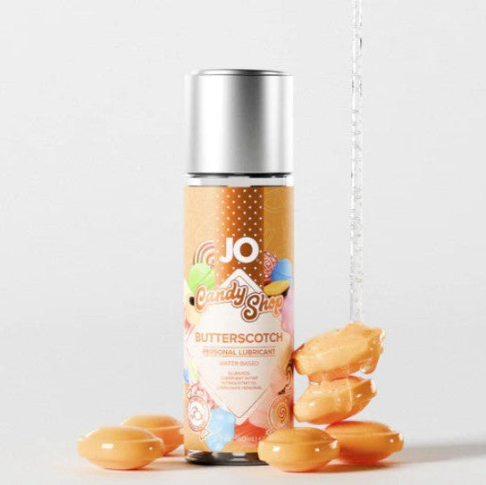 JO H2O Candy Shop Butterscotch Flavored Lubricant bottle with water splash and butterscotch candies on neutral background