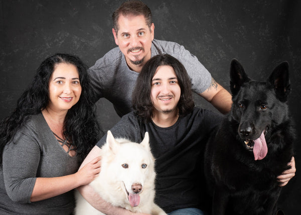 Linda Koontz family of three with two dogs against a dark background