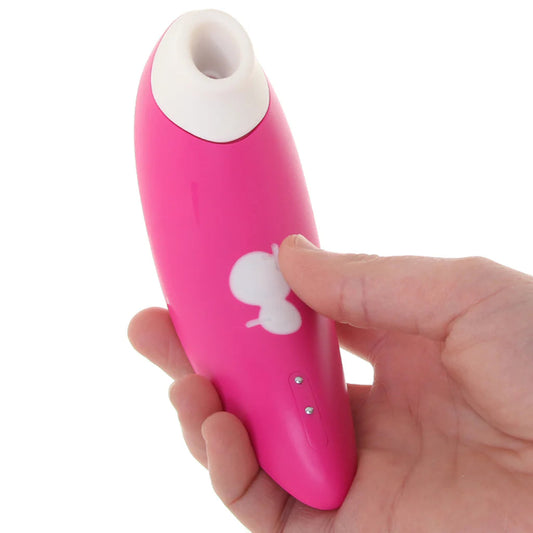 Person holding Romp Shine rechargeable pink clitoral stimulator with silicone suction tip 