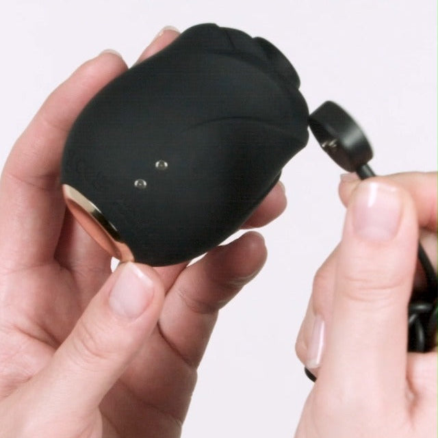 Fifty Shades of Grey Black Rose 2.0 handheld suction toy showing magnetic USB charging cable