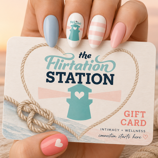 Gift card from 'The Flirtation Station' held by a hand with pastel nail polish.