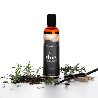 A bottle of aromatherapy Vanilla chai massage oil shown with vanilla sprigs on white background