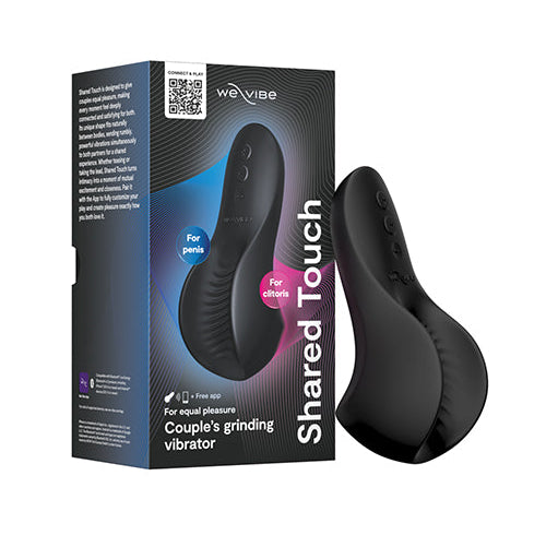 We-Vibe Shared Touch black double-sided couples grinding vibrator displayed beside its retail packaging.