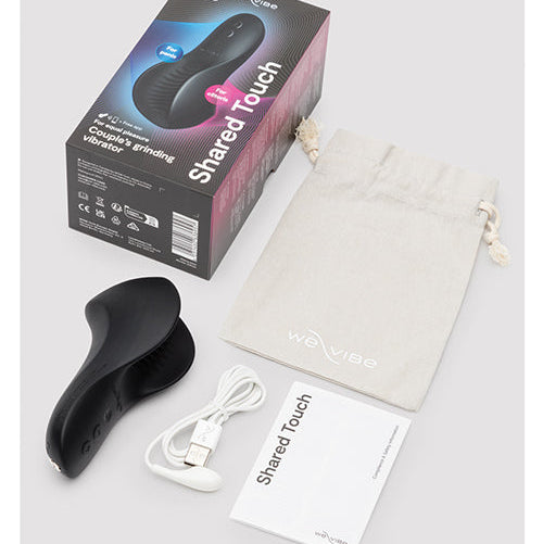 We-Vibe Shared Touch black vibrator with retail box, USB charging cable, storage pouch, and instruction booklet.